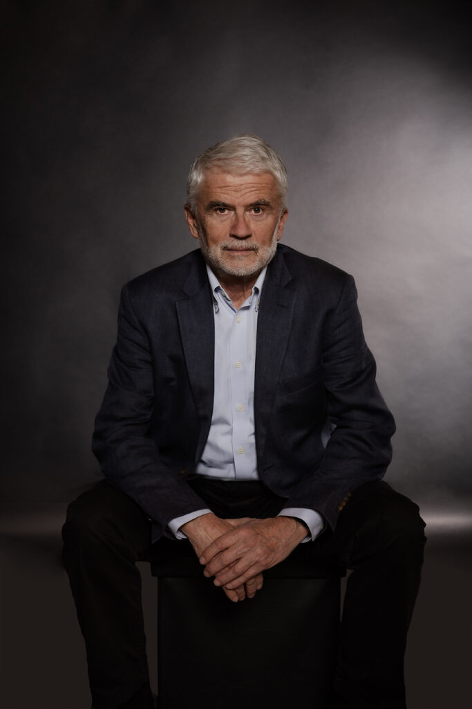 Portrait von Dr. Peter Maydl in dunklem Sakko vor grauem Hintergrund, frontal sitzend und mit ruhigem Blick in die Kamera.