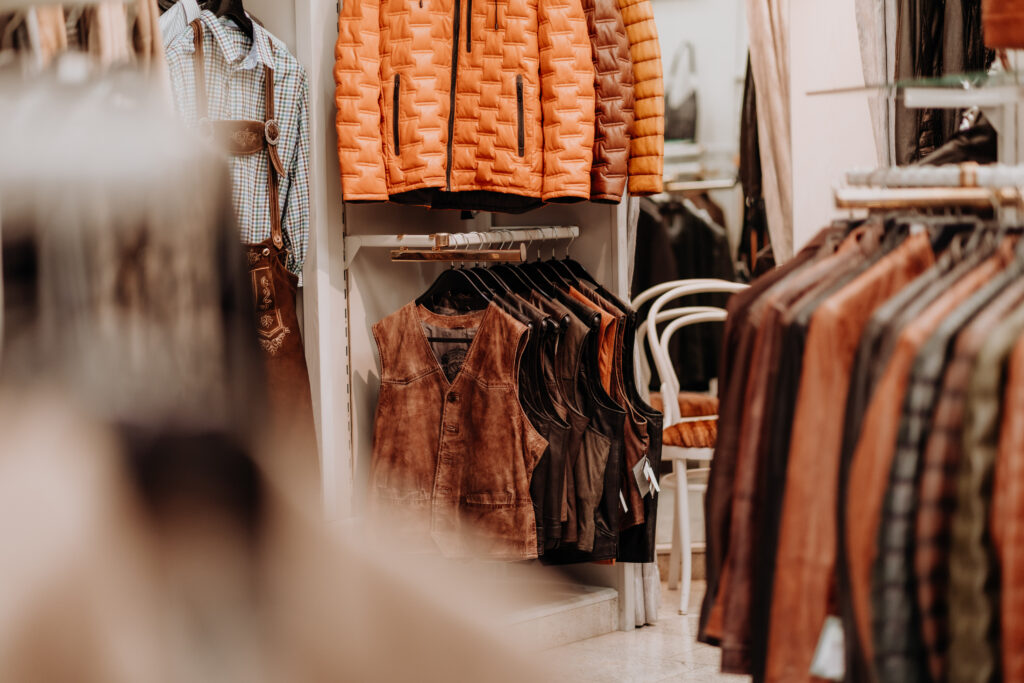 Detailaufnahme von Lederwesten, Trachtenhemden und Steppjacken im Geschäft Stoichart Leder.