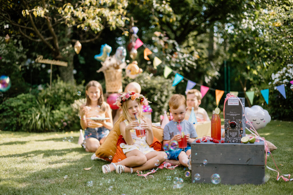 Kinder feiern im Garten mit Getränken von FREIGEIST in sommerlicher Atmosphäre