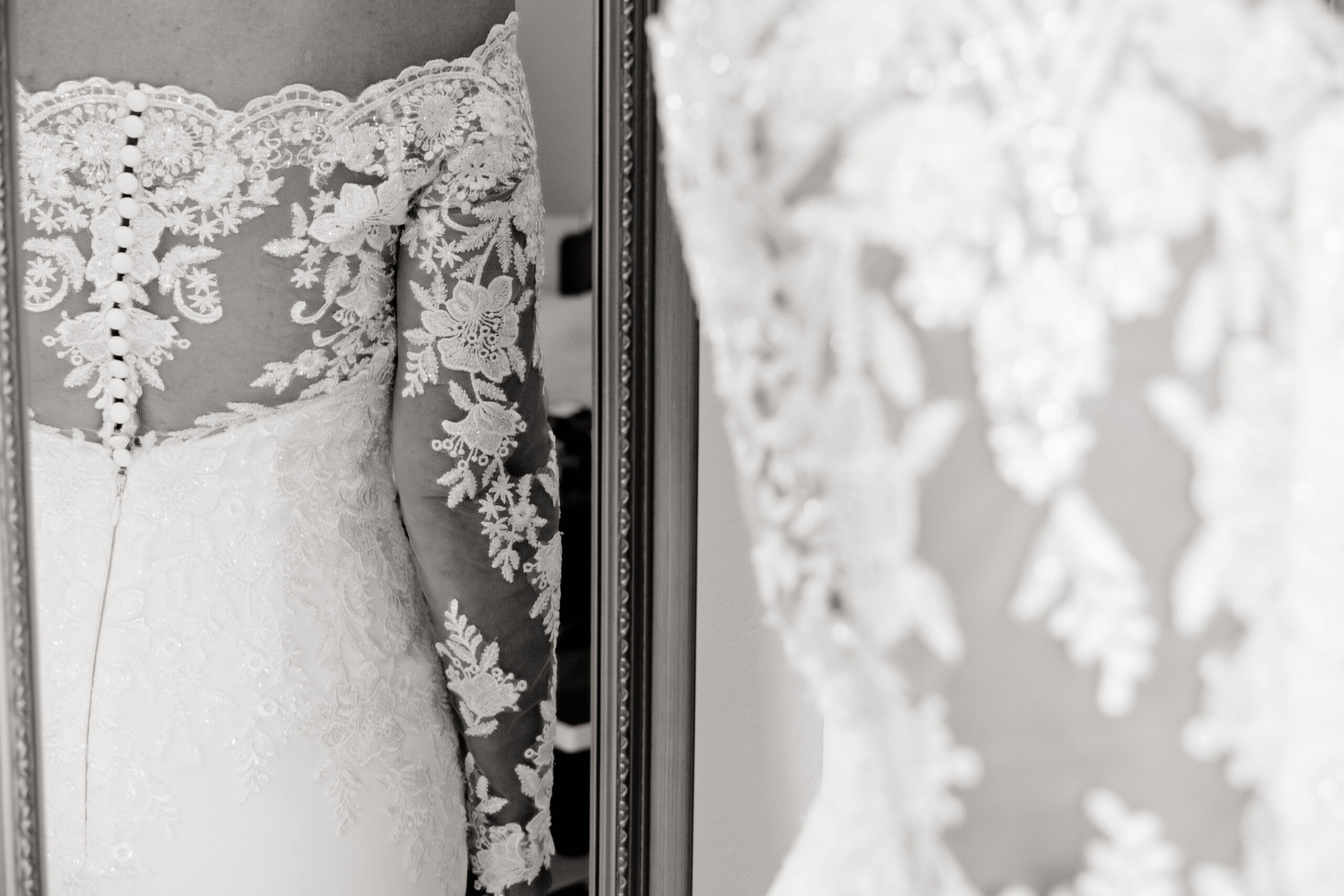 Nahaufnahme von Spitze und Stoff des Brautkleids.