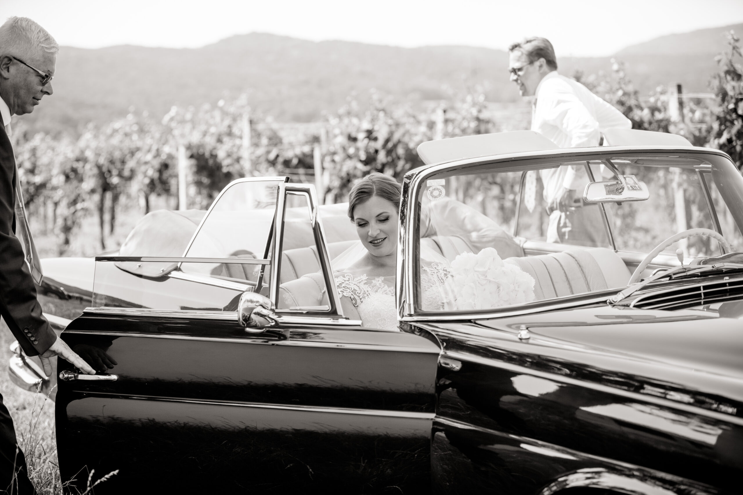 Braut steigt aus einem Oldtimer aus
