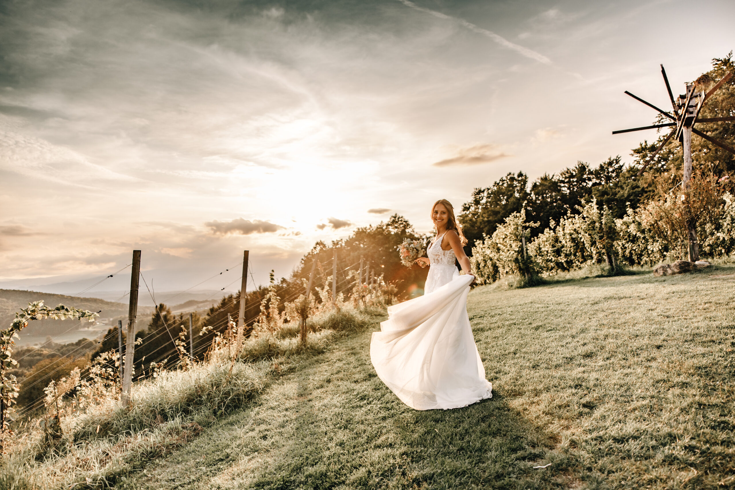 Braut dreht sich beim Brautpaarshooting zwischen Weinbergen