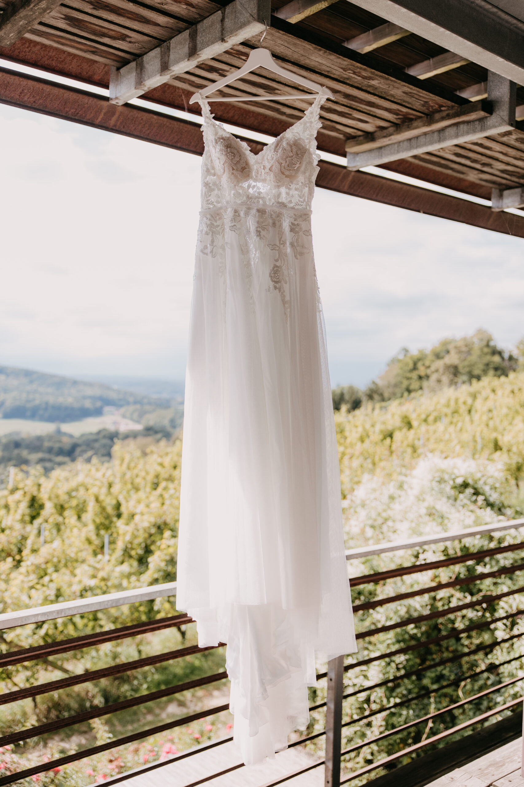 Brautkleid hängt vor einem Fenster.