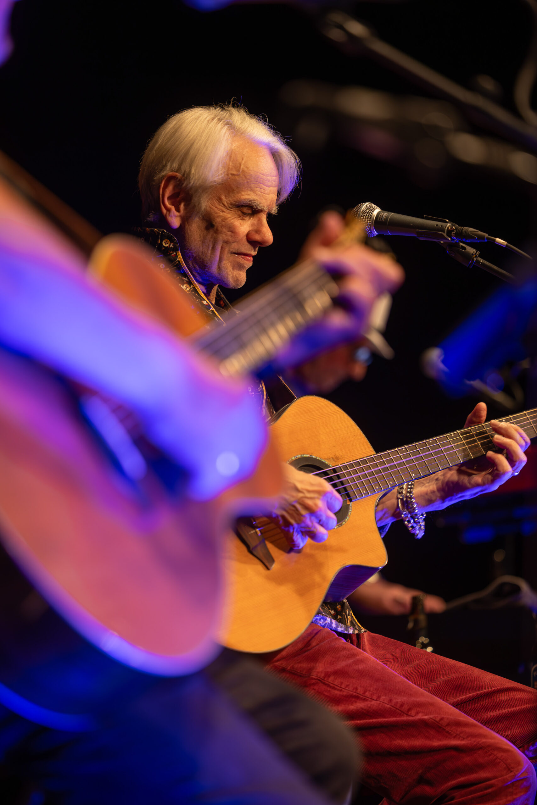 Musiker mit Gitarre auf Bühne – Konzertfotografie