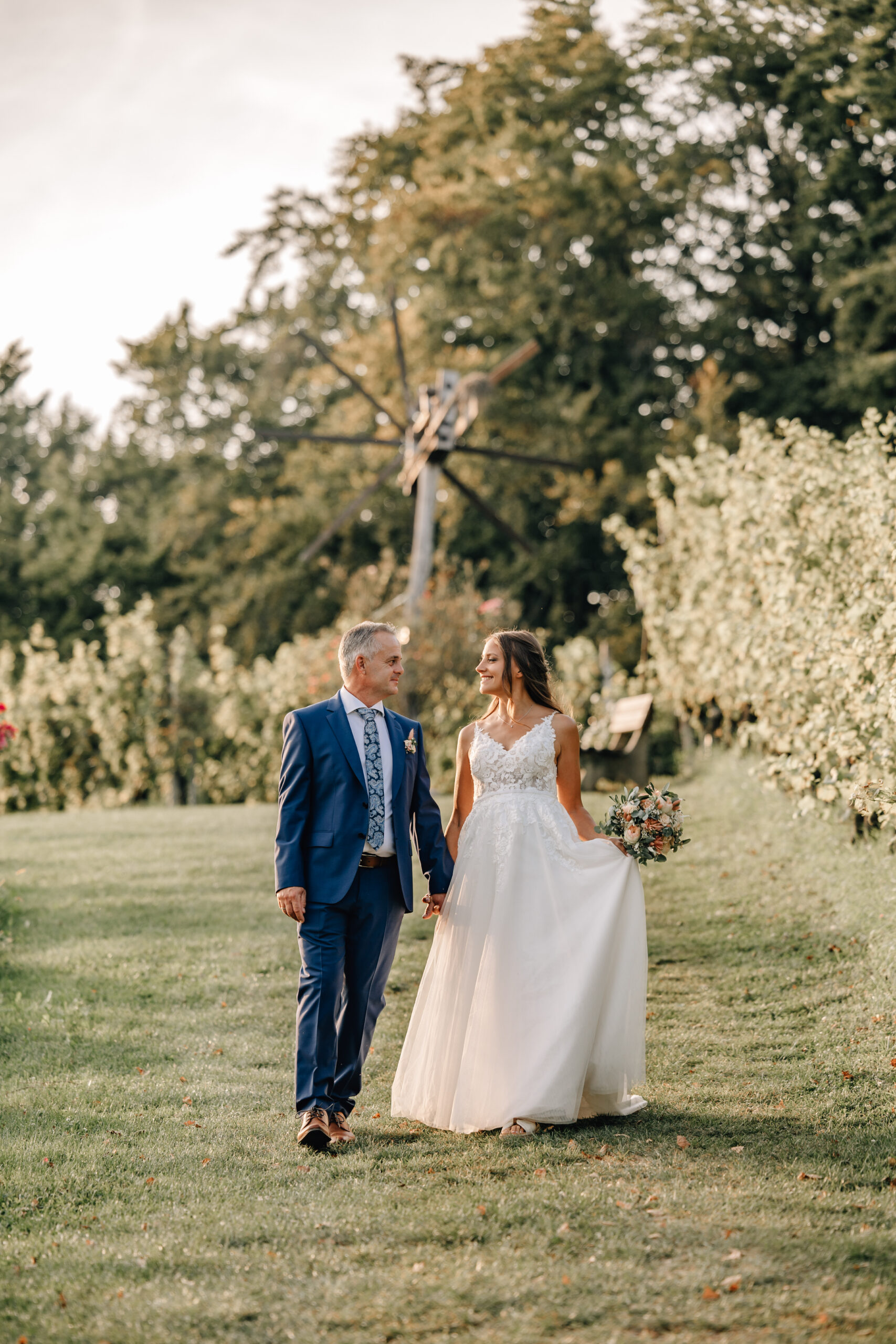 Brautpaar spaziert durch Natur – Hochzeit im Grünen