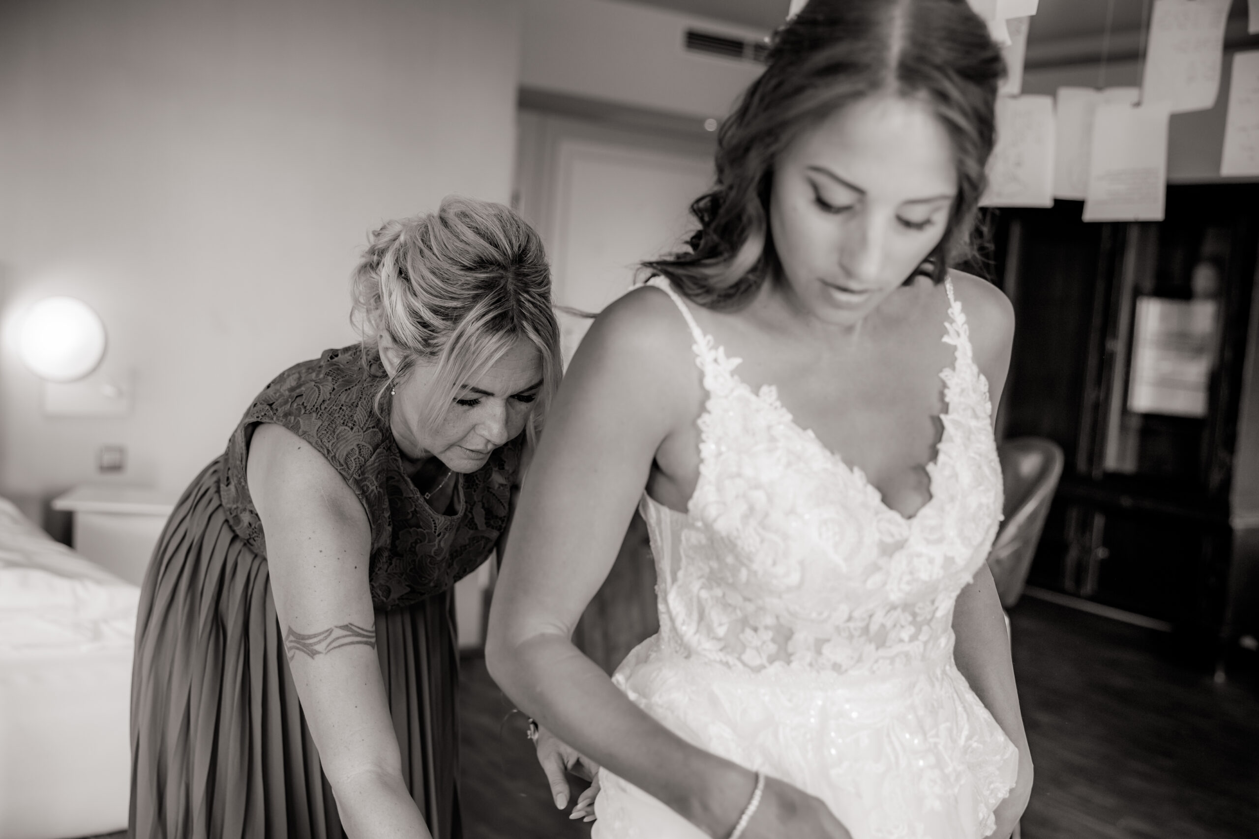 Braut wird ins Kleid geholfen – Hochzeitsmoment